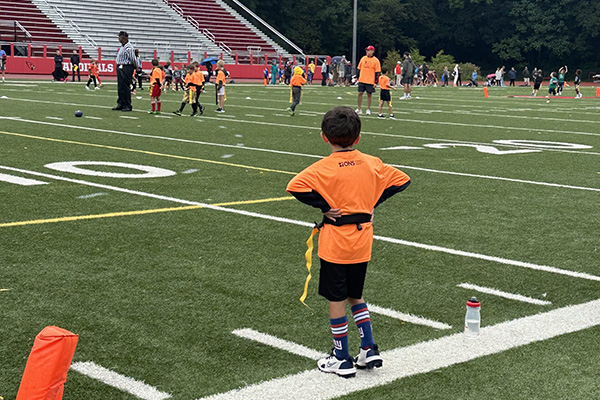 A football game on a green field with children and adults, youth sports, outdoor activity, Ocean Cit.